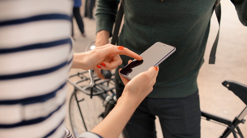 person med mobiltelefon i handen