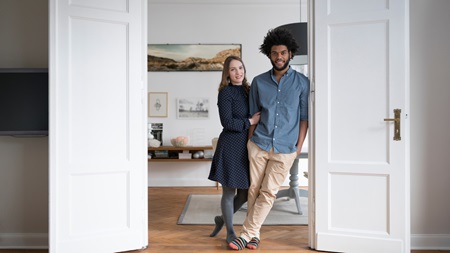 Man och kvinna håller om varandra i dörröppning