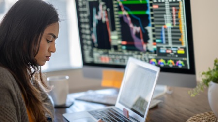 Person sitter och analyserar valutamarknader och valutahandel